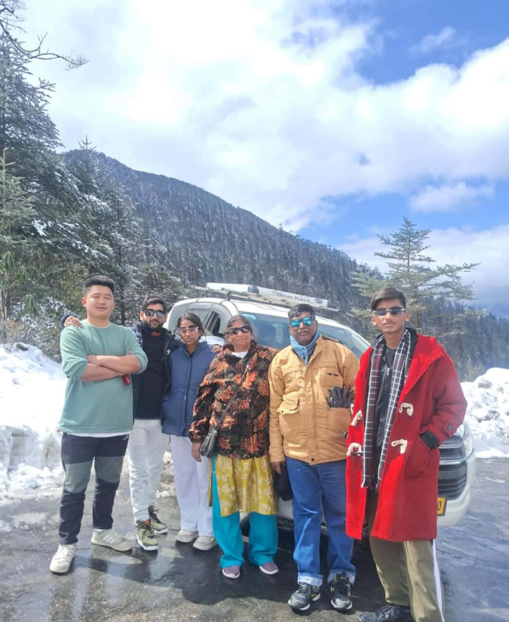 A family's private vehicle on a snow-lined mountain road in Sikkim, the kind of car-based journey used to reach Gangtok from Bagdogra airport and NJP railway station.
